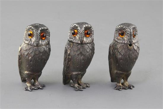 A set of three 1960s novelty silver three piece condiment set, each modelled as a free standing owl, by William Comyns & Sons,